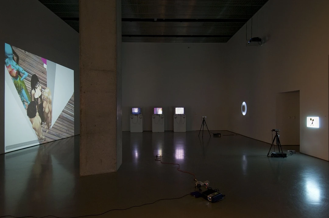 Installation view of the main projection wall and monitor pedestals in Is This Thing On? at the Contemporary Arts Center, Cincinnati, December 2011. Photo by Tony Walsh.