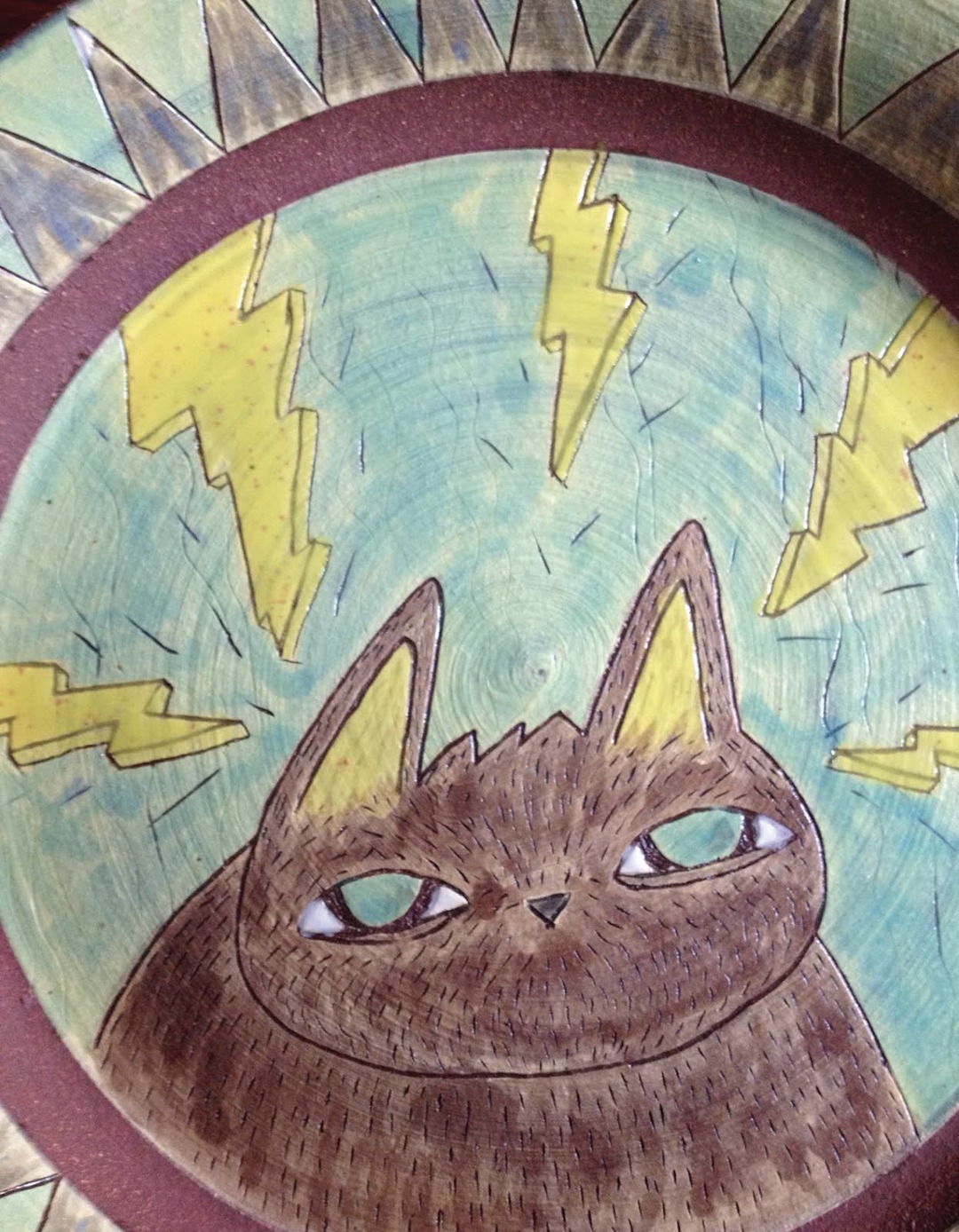Ceramic plate with a cat and lightning bolts by Katie Swartz, another piece from the “Be Easy” exhibition at 1305 Gallery, Cincinnati, 2012. Photo: 1305 Gallery. (Related image located during this archive's reconstruction.)