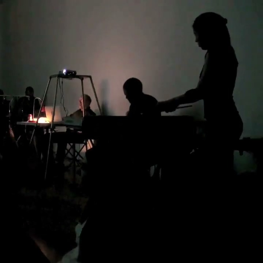 Audience and musicians during the “Lateral Thinking” live cinema and music improvisation performance by viDEO sAVant at Third Party Gallery, Cincinnati, September 8, 2012. Still from the performance documentation by Charles Woodman. (Related image located during this archive's reconstruction.)