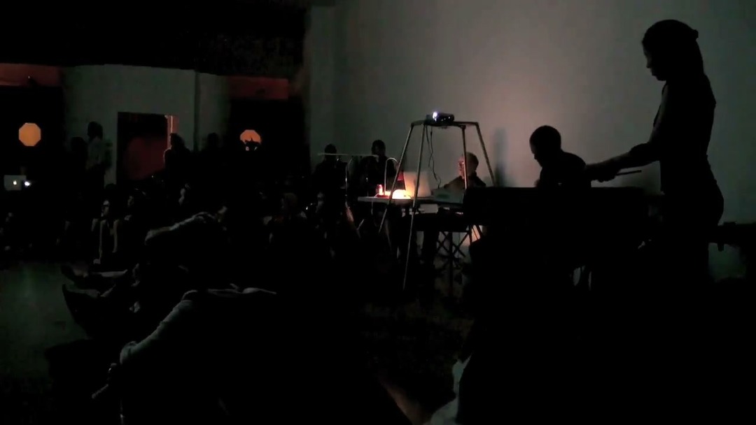Audience and musicians during the “Lateral Thinking” live cinema and music improvisation performance by viDEO sAVant at Third Party Gallery, Cincinnati, September 8, 2012. Still from the performance documentation by Charles Woodman. (Related image located during this archive's reconstruction.)