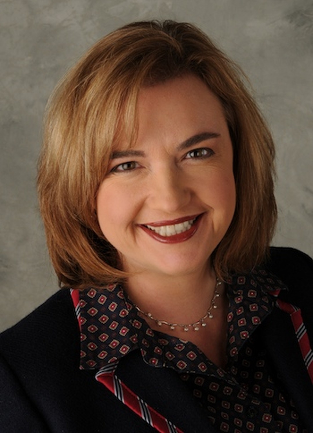 Studio headshot of Alecia Kintner, a smiling woman with shoulder-length light brown hair.