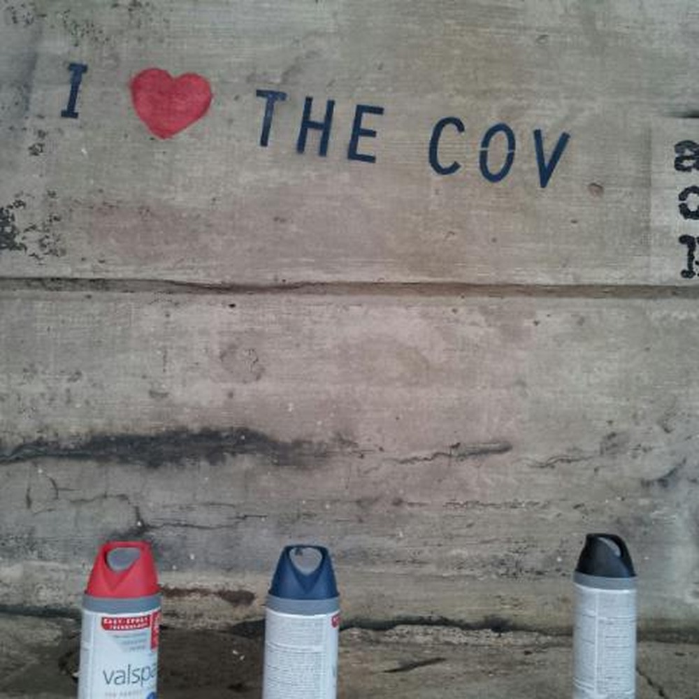 Close-up of the 'I love the Cov' street stencil with spray cans.