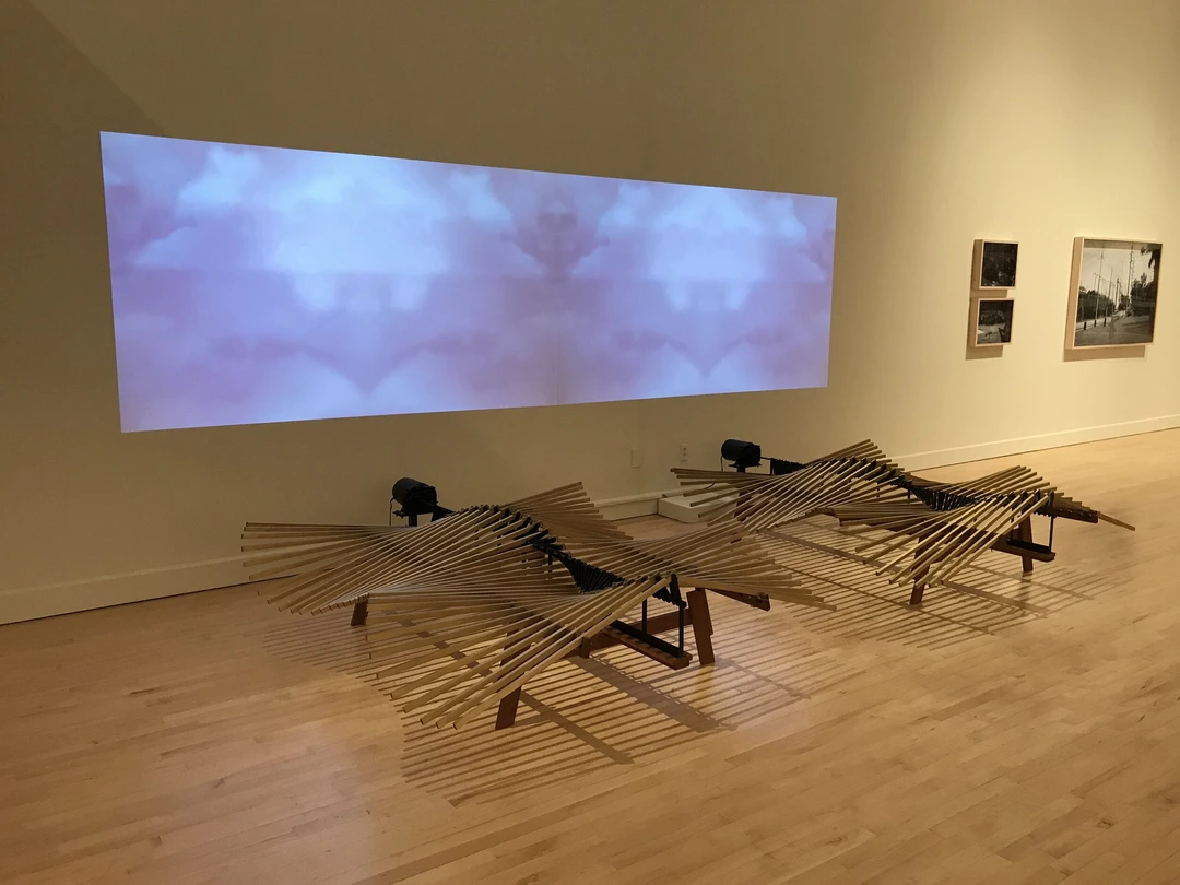John Douglas Powers kinetic sculpture Haliades showing undulating wooden slats, motor drive, and sky projection.
