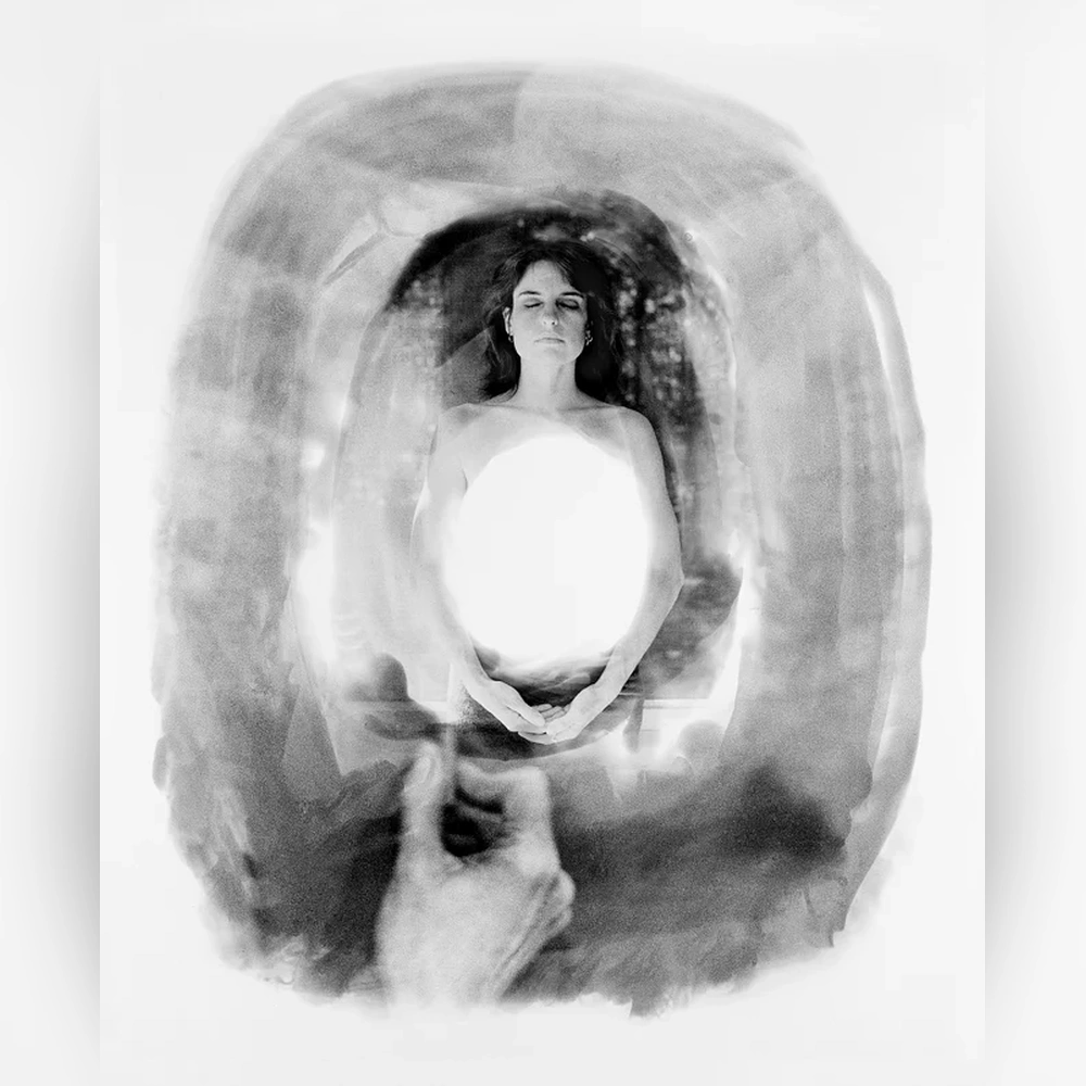 A black-and-white photographic montage shows a woman holding a bright oval of light before her torso, surrounded by overlapping portraits.