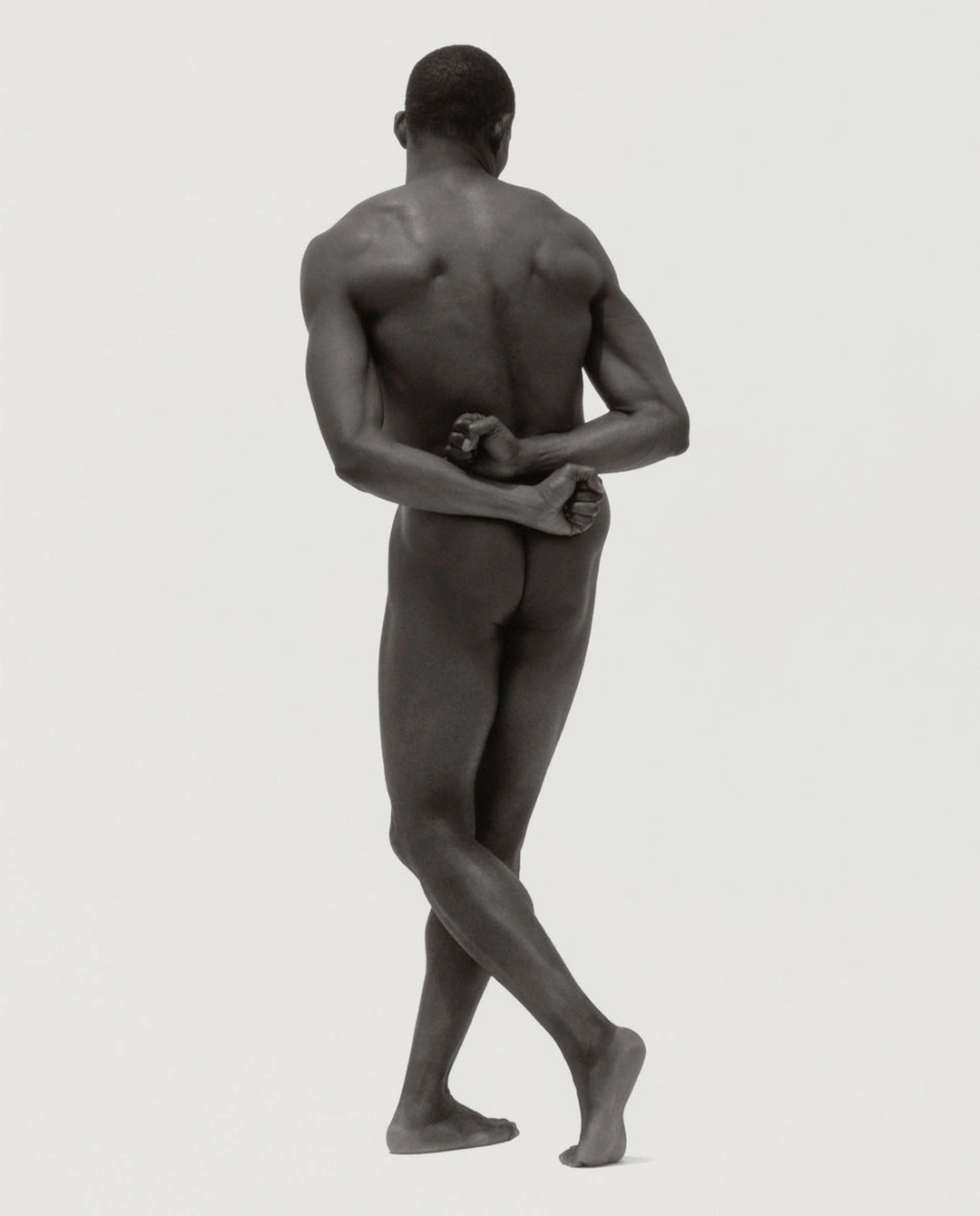 A nude dancer viewed from behind balances on crossed feet with his arms folded across his lower back against a pale background. Herb Ritts “Bill T. Jones VI, Los Angeles” 1995 Gelatin silver print Image: 35.6 x 27.9 cm (14 x 11 in.) Framed: 55.9 x 45.7 cm (22 x 18 in.) Los Angeles, California, United States, North America The J. Paul Getty Museum, Los Angeles, Gift of Herb Ritts Foundation © Herb Ritts Foundation