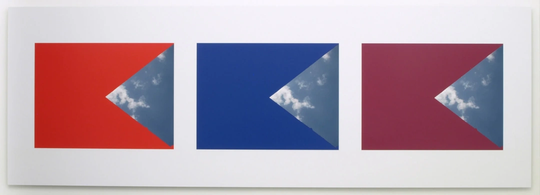Three framed geometric sky photographs form a horizontal panel, with red, blue and purple shapes surrounding triangular areas of cloud. Stephen Berens, “Thinking of Pinturicchio (While Looking Out Sol LeWitt’s Windows),” 2010-2012, archival inkjet prints on paper mounted directly on the wall, each panel: 24 x 70 inches. Photo by Chris Gomien.