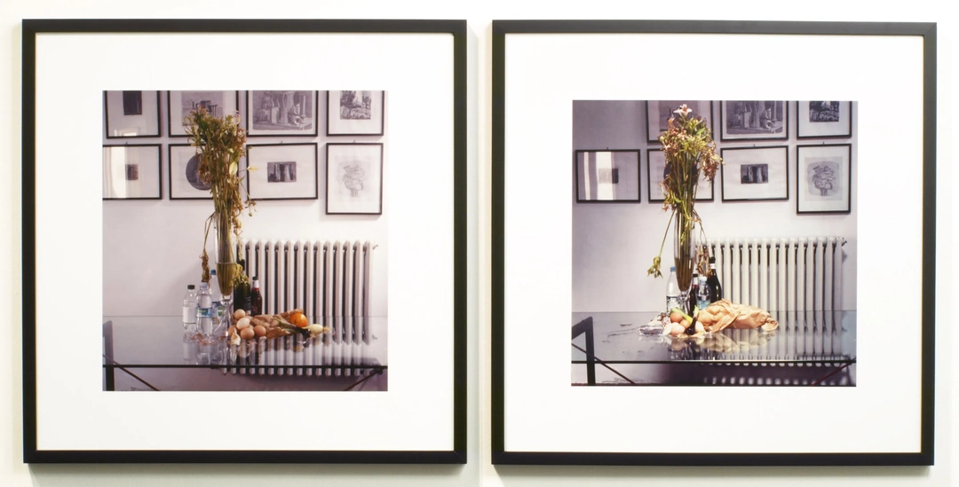 A framed photographic diptych shows a glass dining table with food and bottles beneath a tall floral arrangement, with a radiator and framed etchings behind it. Elizabeth Bryant, “SLW Studio Still Life: Upstairs Dining Table,” 2010-2012, archival inkjet prints on archival mount board with archival matte laminate, two 24 x 24”, edition of 5, 1/5. Photo by Chris Gomien.