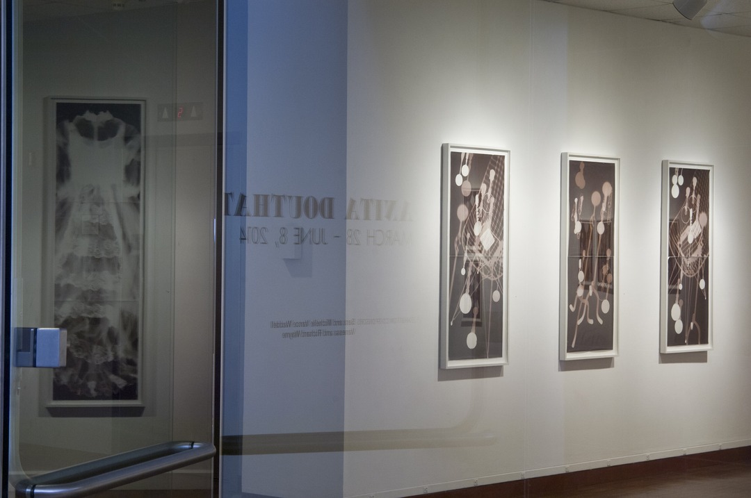Gallery installation view with framed photograms of chair and candelabra forms on a white wall.