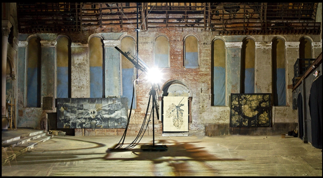 Wide view of the Holy Cross Church interior with a carbon arc lamp and large photographic panels along the arched brick walls.