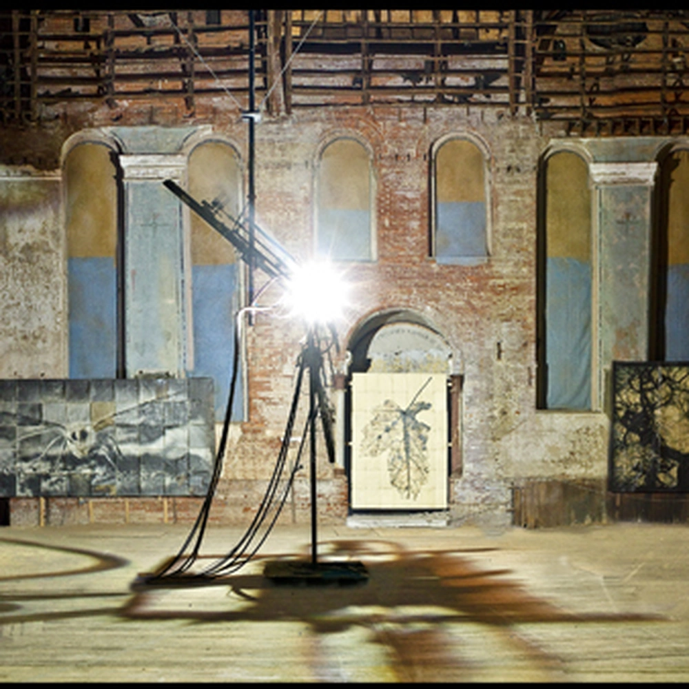 Carbon arc lamp and photographic panels against the arched brick walls of Holy Cross Church.