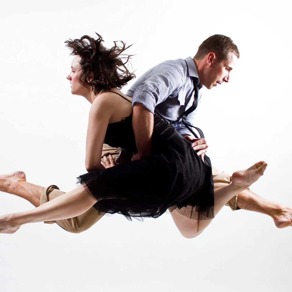Detail of a MamLuft&Co. Dance duet in mid-air, a male dancer lifting a female dancer in a black dress.