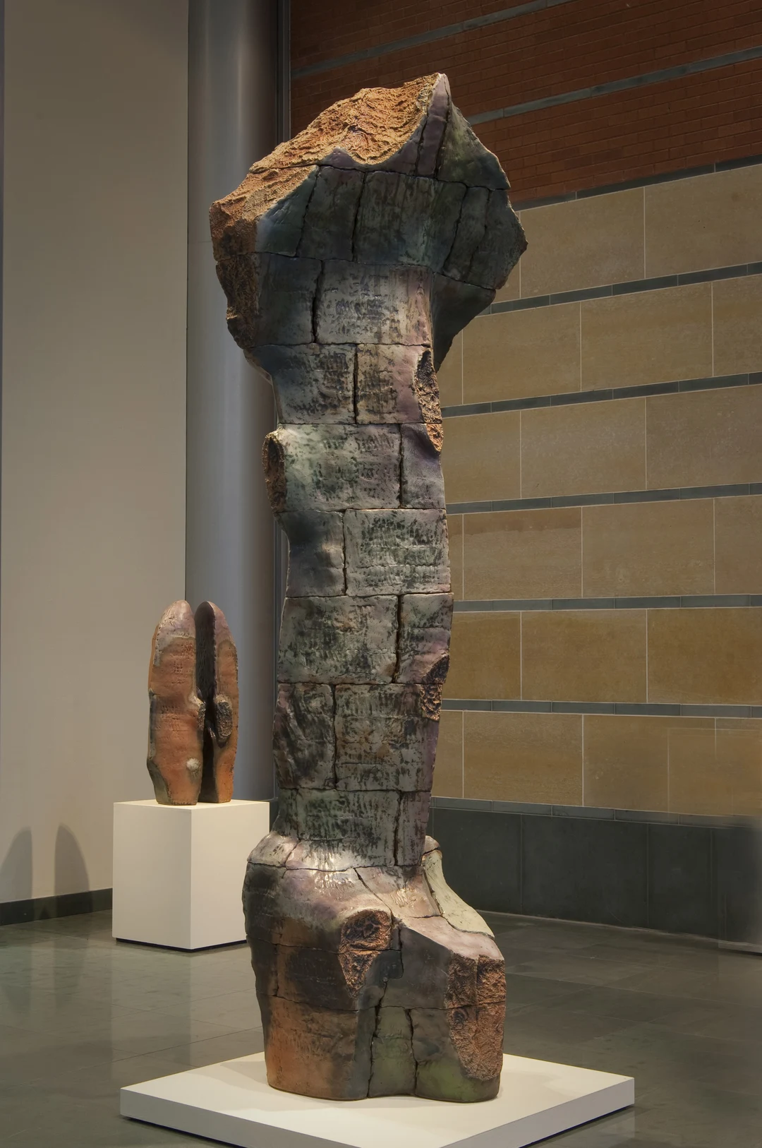Serpent by Robert Pulley: a tall, craggy ceramic sculpture of stacked, rock-like forms in earthy brown and grey tones, standing in a gallery.