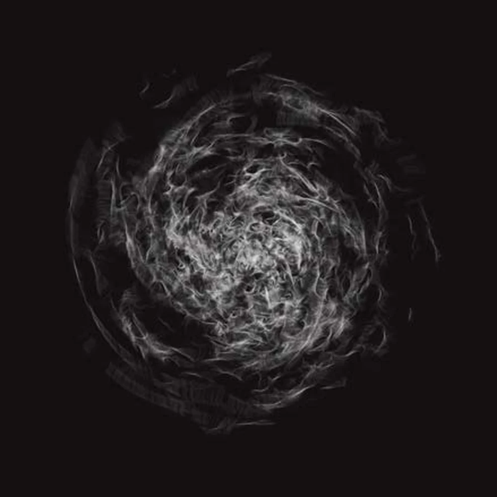 Swirling white smoke-like circular form on a black background.