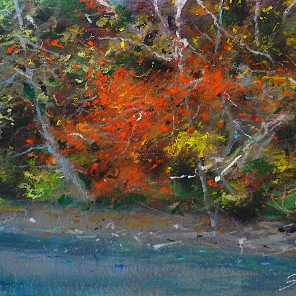 Woodland waterway bordered by dense autumn foliage in red, orange, yellow and green, dissolving into expressive strokes of color; calm blue-grey water fills the foreground.