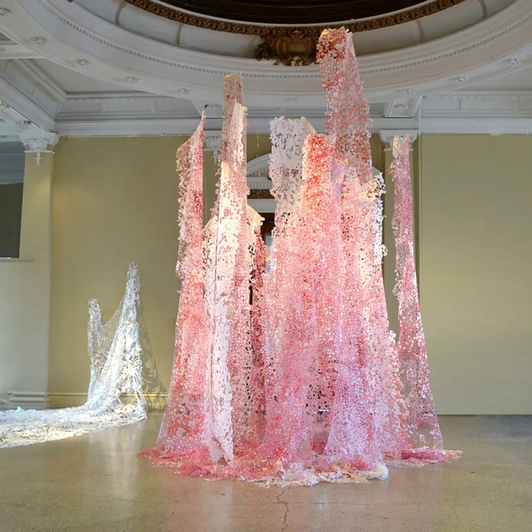 Large-scale cut paper installation with draped pink and white lace-like forms in a gallery. Kristine Donnelly, Ebb and Flow. Image from Ohio Women in the Arts. (Related image located during this archive's reconstruction.)