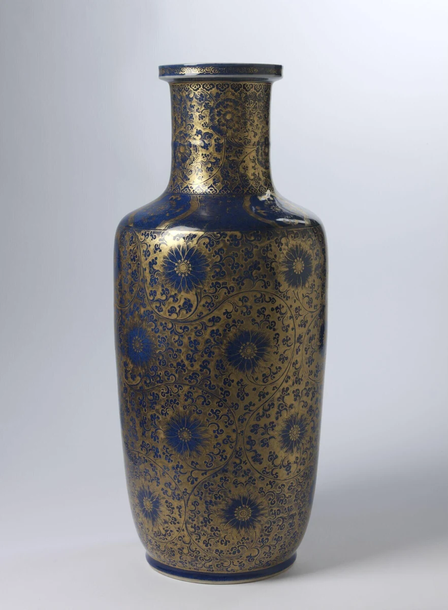 Tall rouleau vase with deep powder-blue glaze densely decorated in gilt with chrysanthemum blossoms and scrolling foliage. Chinese, Kangxi period (1662–1722), Rouleau vase with powder-blue glaze and gilt chrysanthemum decoration, porcelain, H. 45.7 cm. Image from Victoria and Albert Museum. (Related image located during this archive's reconstruction.)