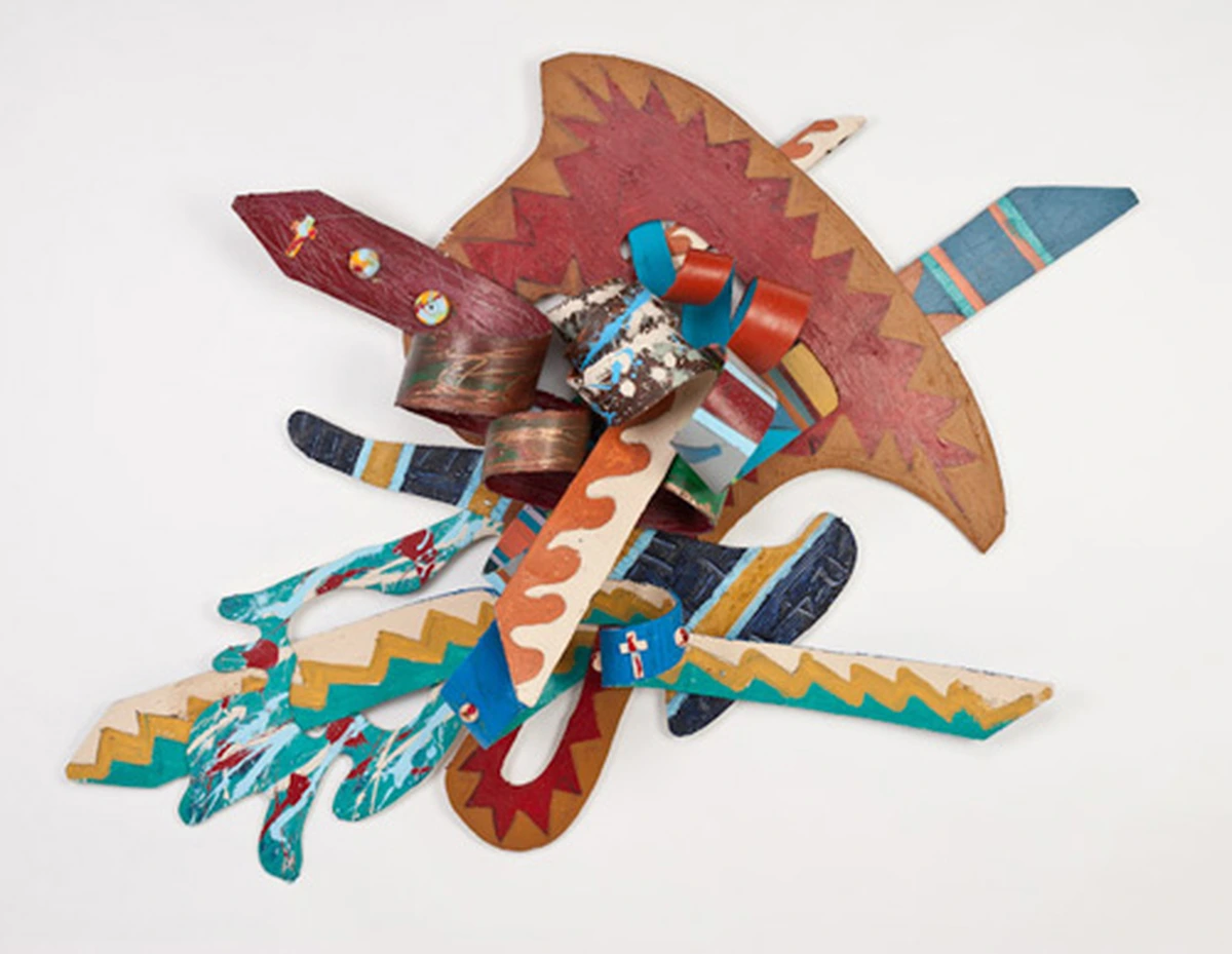 Kevin Cole, Blessings with No Limitations I: a wall relief of layered, painted wooden shapes with zigzag patterns in rust, turquoise, cream and red, projecting outward like a burst.