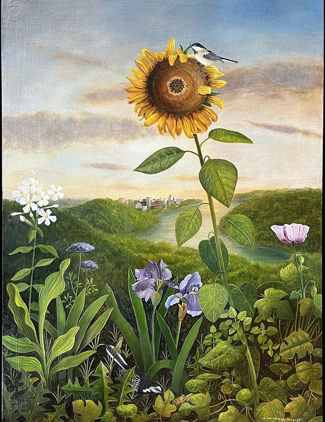 A tall sunflower with irises and other flowers in a hilly landscape.