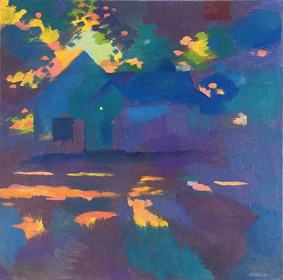 Blue house at dusk surrounded by colorful foliage.