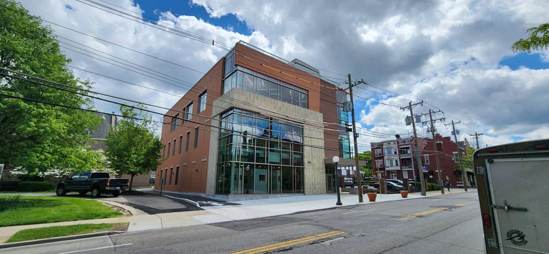 The Clifton Cultural Arts Center building, a modern brick building with a tall glass entrance, viewed from the street.