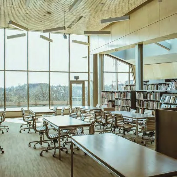 Bright modern library reading room with long wooden tables and rolling chairs, floor-to-ceiling windows overlooking the city, and bookshelves along the right wall. The new Mary R. Schiff Library and Archives in the Longworth Wing of the Cincinnati Art Museum. Image from Cincinnati Art Museum. (Related image located during this archive's reconstruction.)