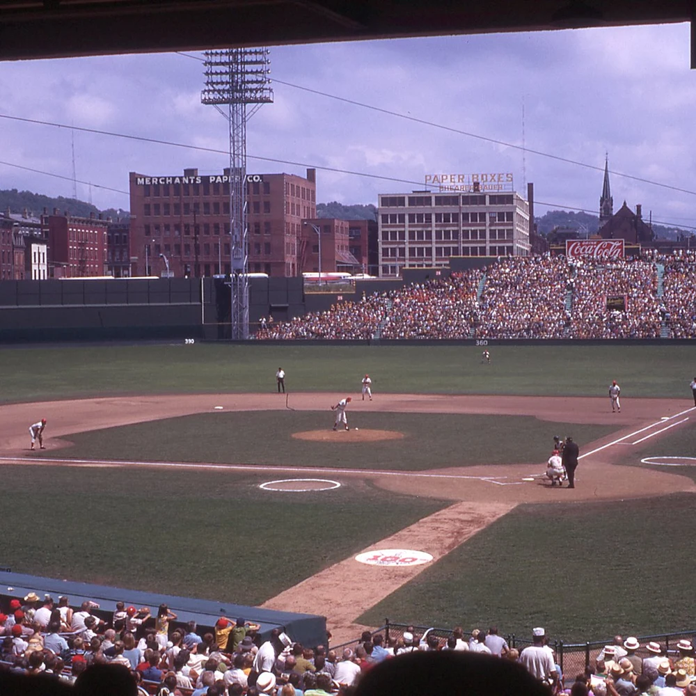 Color photograph of Crosley Field baseball stadium in Cincinnati in 1969, with the field, crowded stands, and surrounding brick buildings.