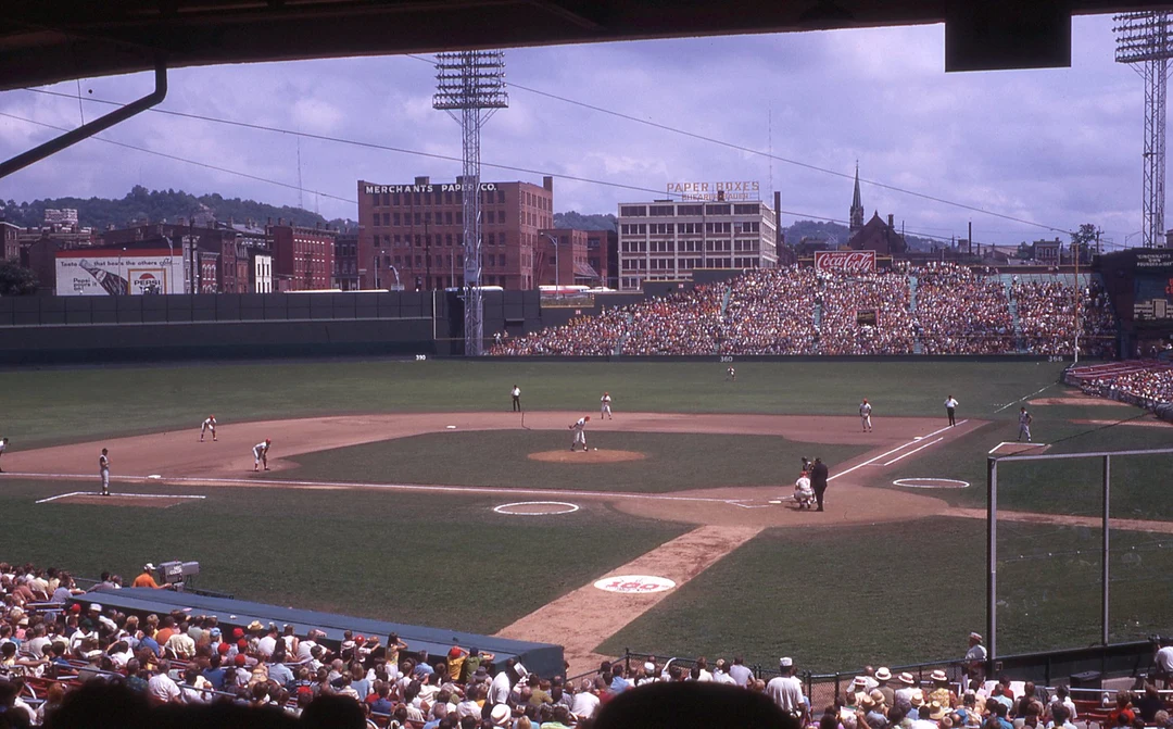 Color photograph of Crosley Field baseball stadium in Cincinnati in 1969, with the field, crowded stands, and surrounding brick buildings.