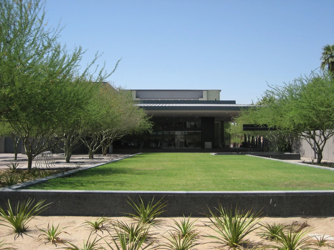 Main entrance of the Phoenix Art Museum: modern building facade with glass doors, green lawn and desert landscaping.