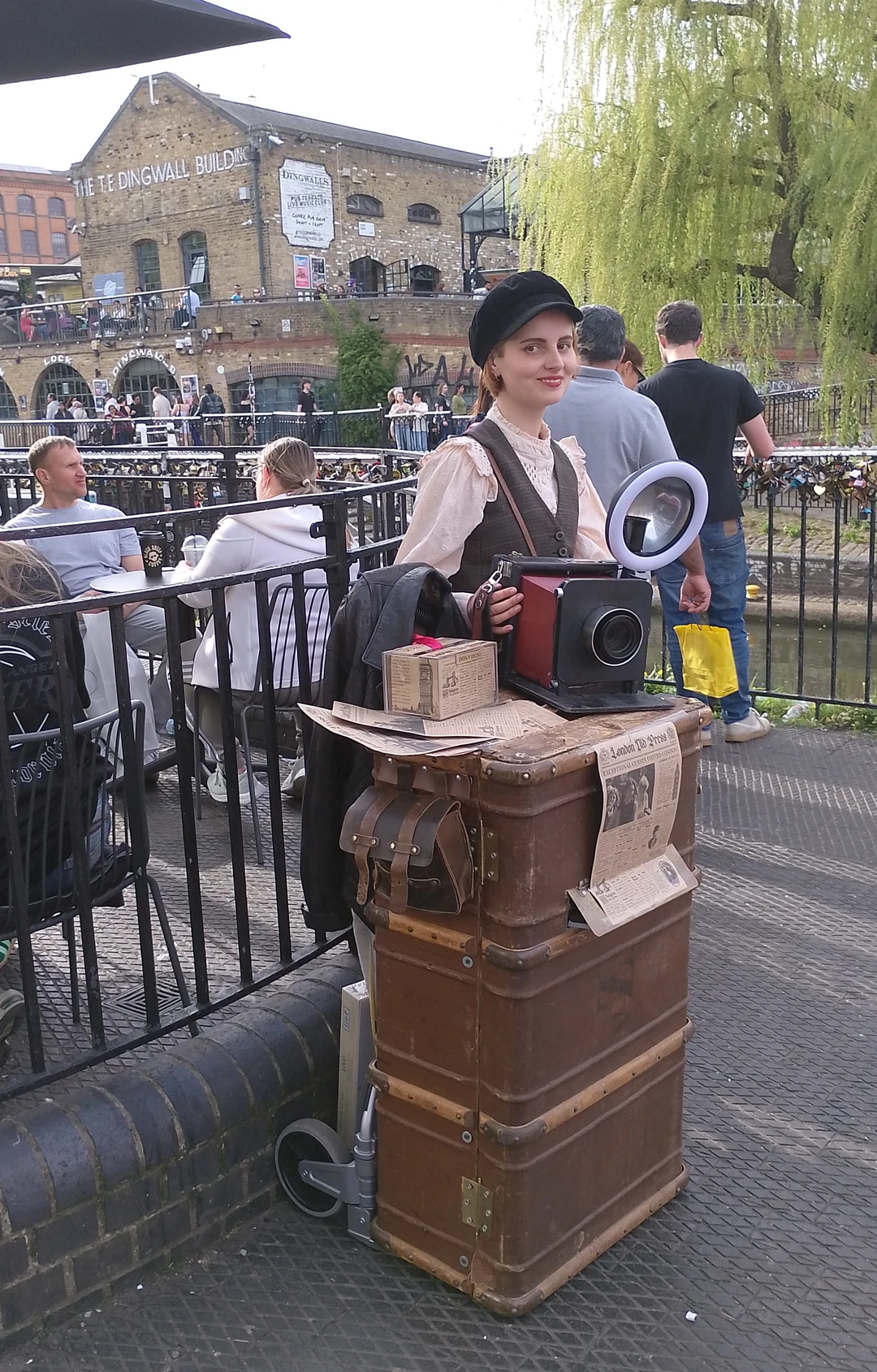 A street photographer with vintage camera equipment at Camden Lock, London.