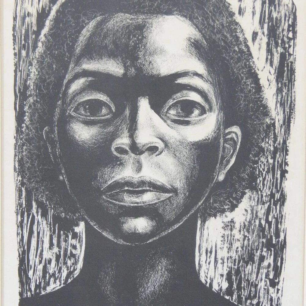 Black-and-white print by Elizabeth Catlett showing the close-cropped face of a woman, titled The Black Woman Speaks.