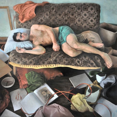Reclining male nude on a patterned sofa with books and papers. Tyler Wilkinson. Image from Manifest Gallery.