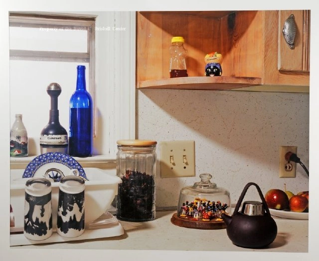 Photograph by Sheila Pree Bright of a kitchen counter with bottles, jars, salt shakers and a teapot.