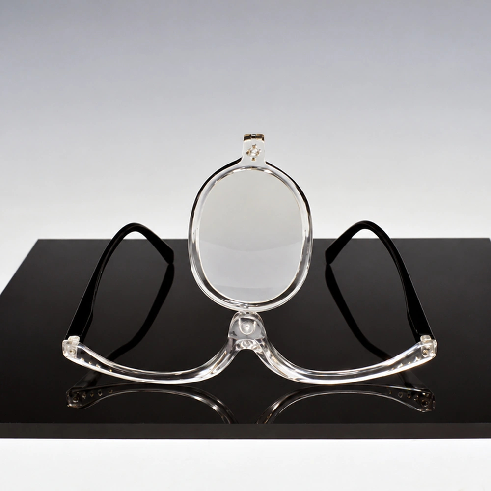 Michael Aurbach, Third Eye: Blind Transcendentalist: clear eyeglass frames with a single oval lens standing upright at the bridge, on a black rectangular base. (Digitally enhanced. May contain discrepancies from the original artwork.)