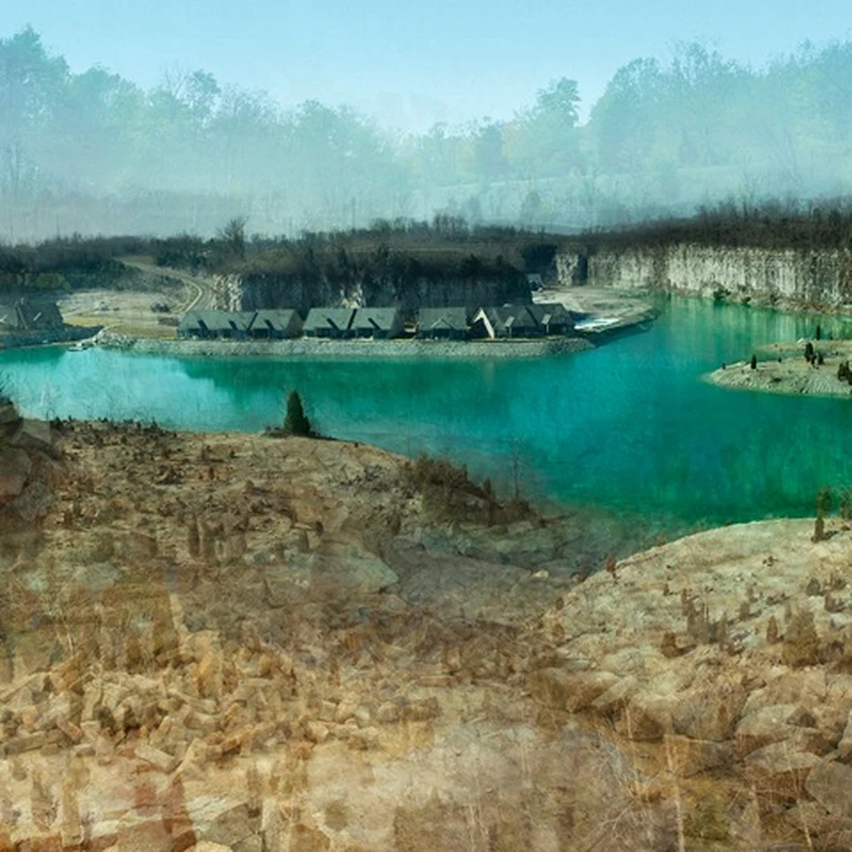 Quarry lake with a row of houses on the far shore under a hazy sky.