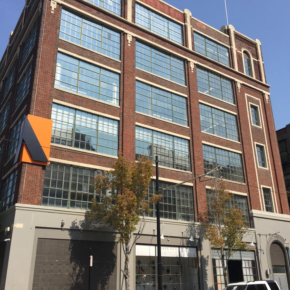 Brick Art Academy of Cincinnati building with large industrial windows on a sunny day.