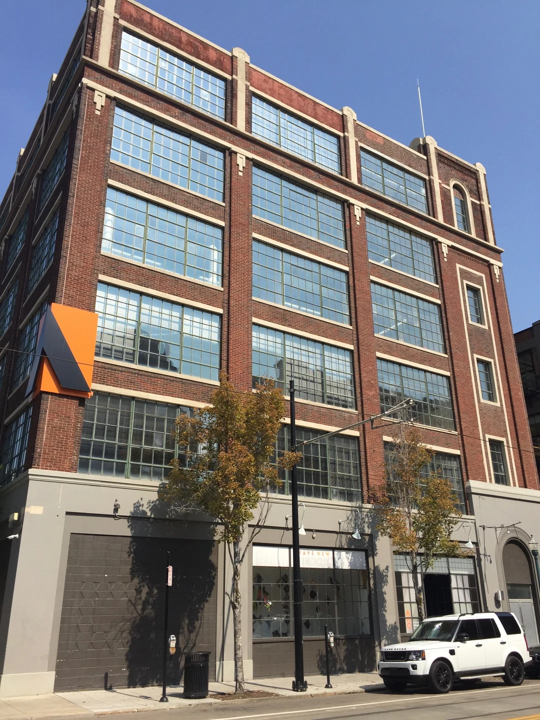 Brick Art Academy of Cincinnati building with large industrial windows on a sunny day.