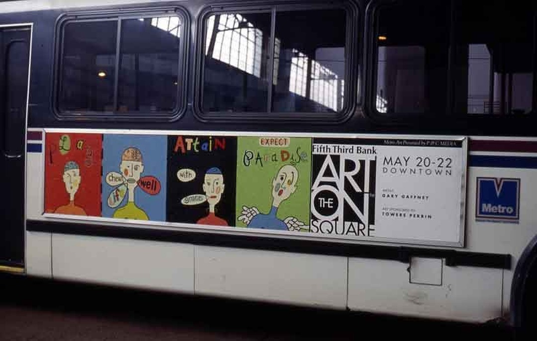 Colorful painted advertisement by Gary Gaffney on the side of a Queen City Metro bus