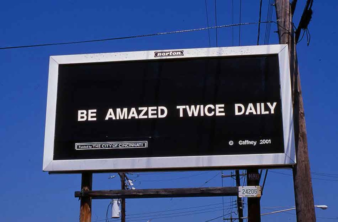 Black billboard reading 'BE AMAZED TWICE DAILY' by Gary Gaffney, funded by the City of Cincinnati