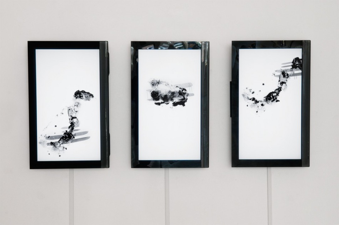 Three framed screens showing black smoke and biplane animations by Kate Shannon