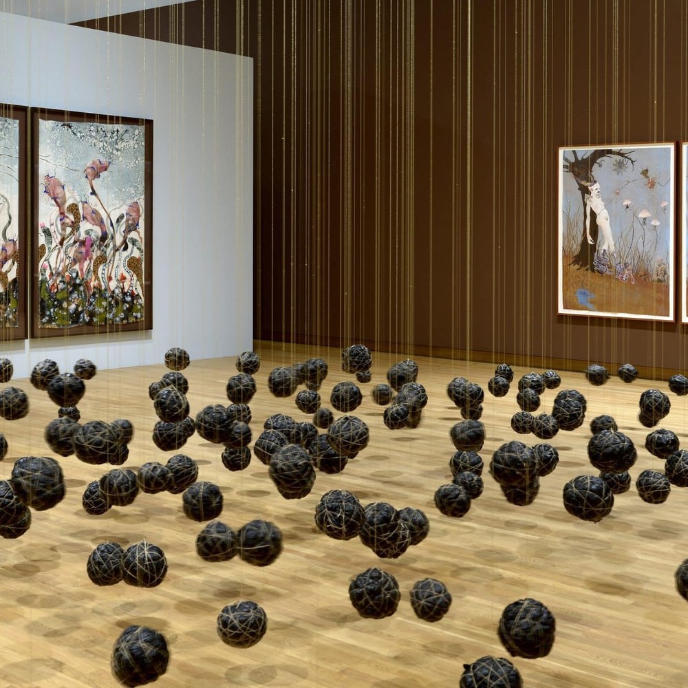 Installation view of Wangechi Mutu’s A Fantastic Journey at the Nasher Museum, showing large-scale collages on the walls and a suspended installation of dark spheres.