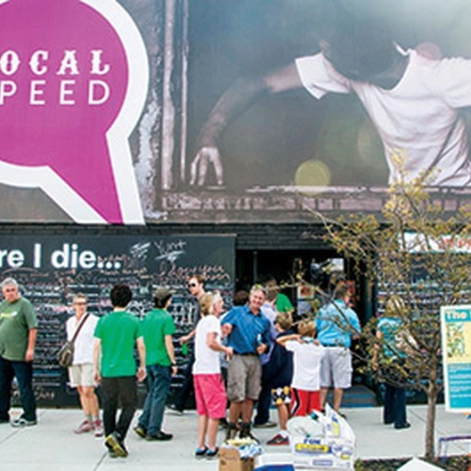 Local Speed storefront with purple speech-bubble logo sign, square crop