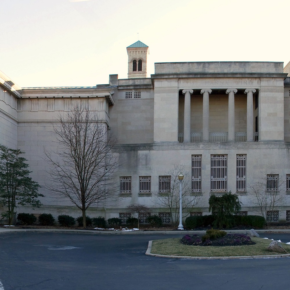 The columned stone facade of the Cincinnati Art Museum on a winter day, with exhibition banners hanging between the columns.