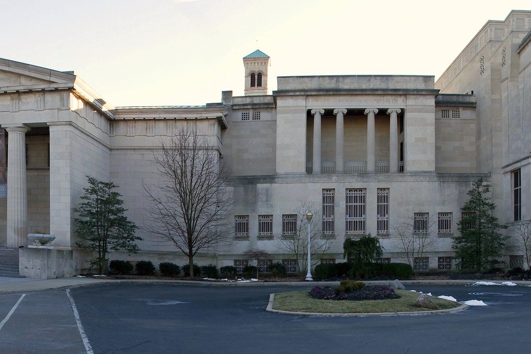 The columned stone facade of the Cincinnati Art Museum on a winter day, with exhibition banners hanging between the columns.