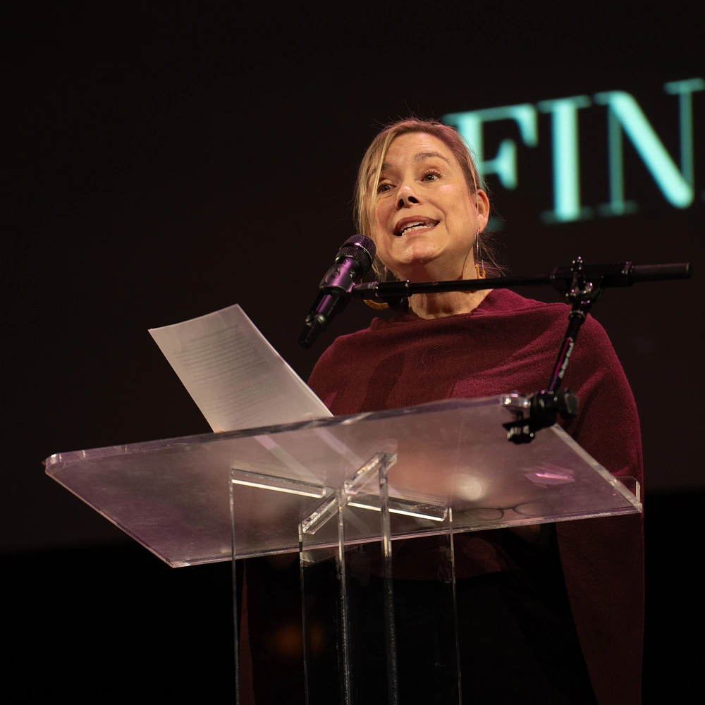 Ruth Dickey speaking at a lectern at the 2024 National Book Awards finalist reading.