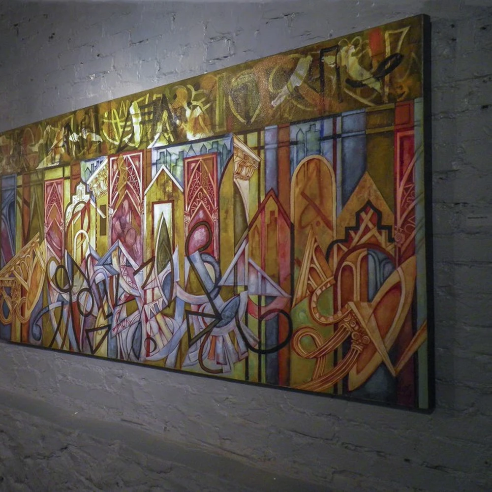Large colorful abstract painting with architectural shapes in gold, red and blue, on a white brick gallery wall.