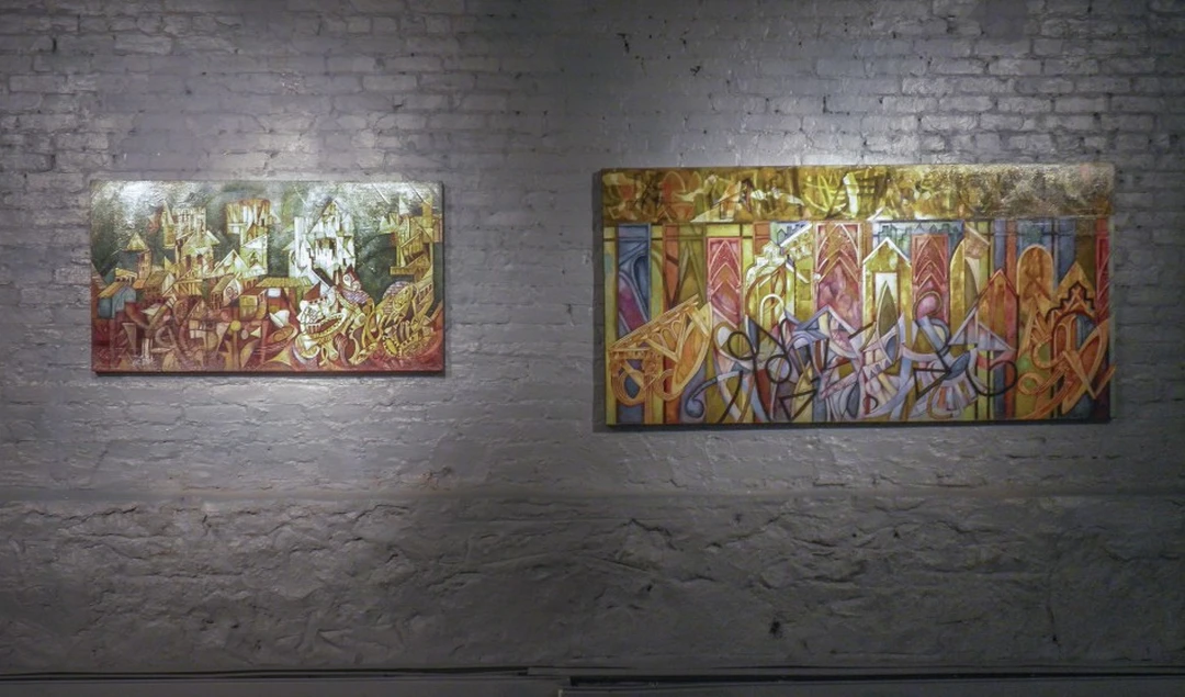 Two large colorful abstract paintings on a white brick gallery wall. Photograph by Cedric Cox.