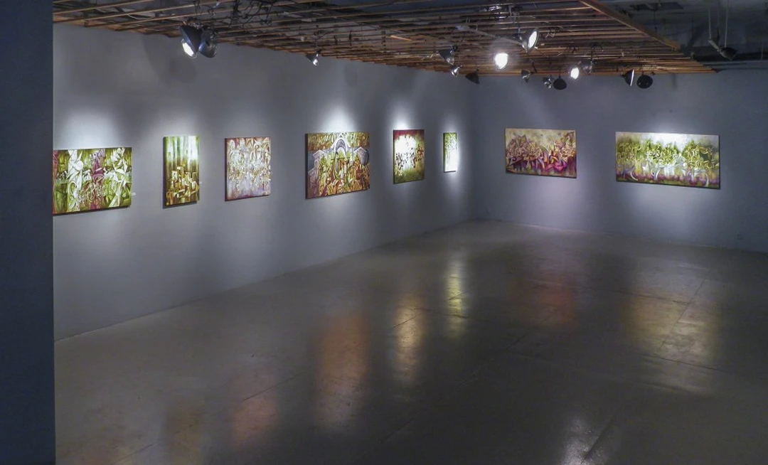 Corner view of a gallery with eight colorful abstract paintings, from a slightly different angle. Photograph by Cedric Cox.