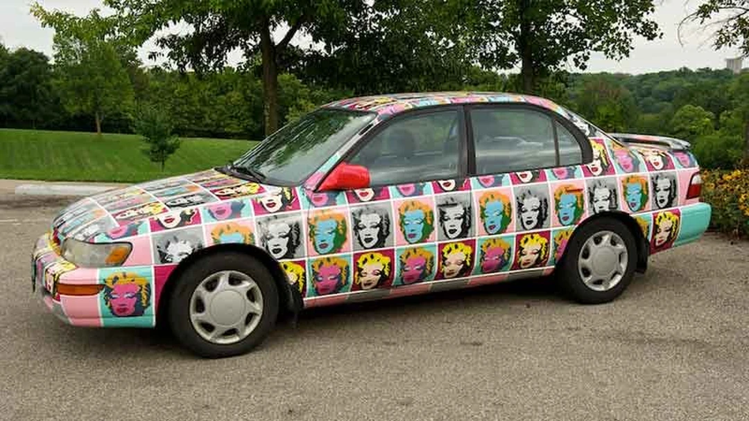 Art car covered with Warhol-style Marilyn Monroe faces in colorful squares.