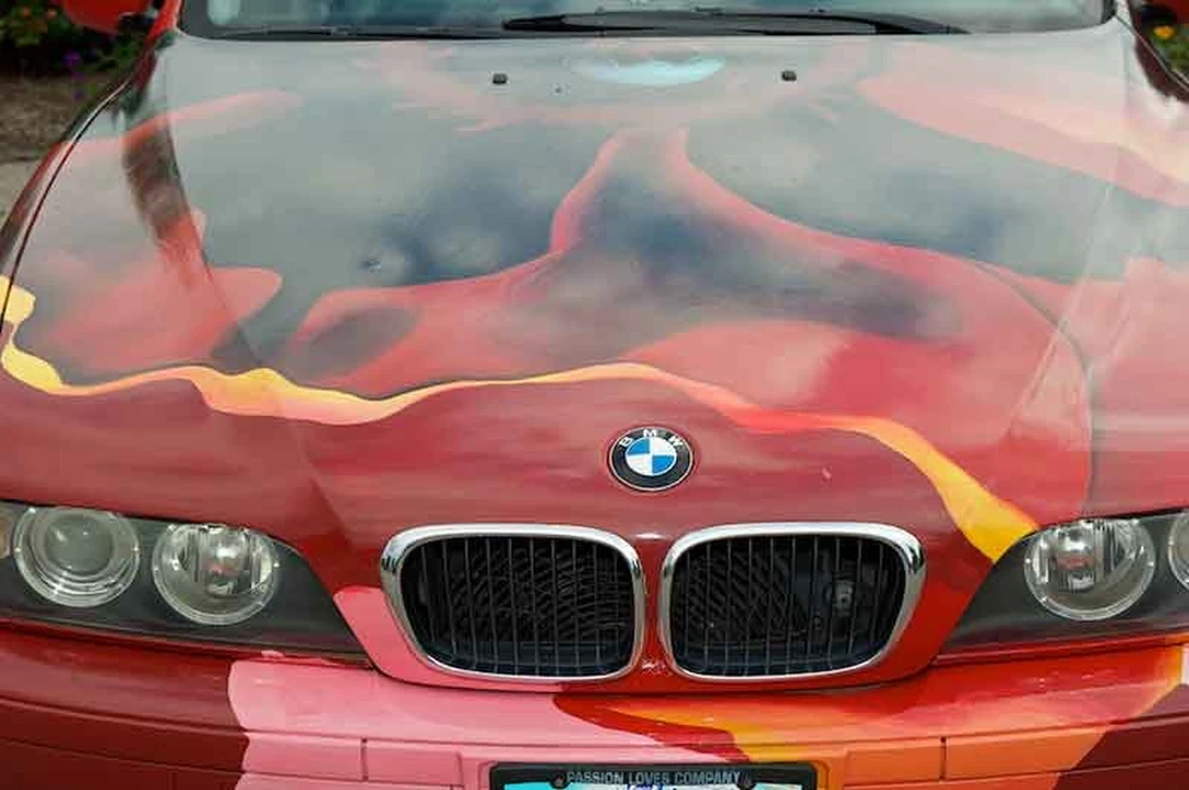 Front of a BMW painted with red and orange flames.
