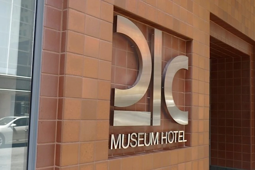 The "21C Museum Hotel" sign in metal letters on a brick wall.